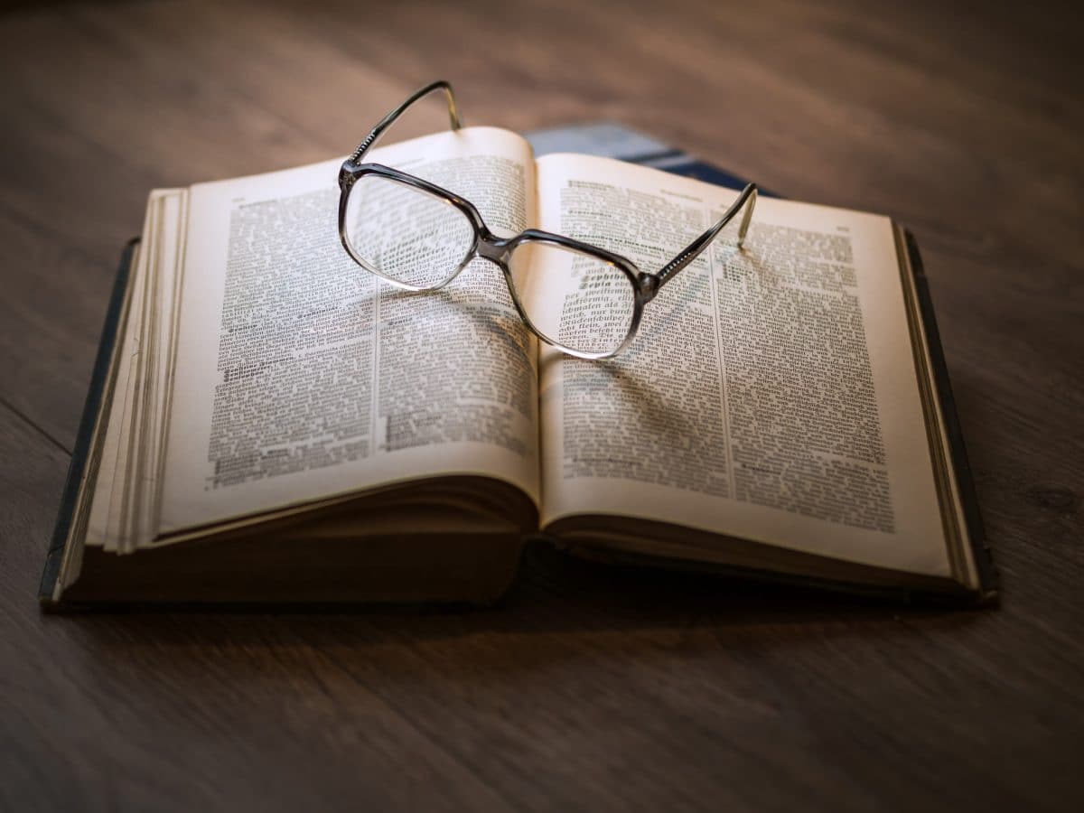 Publishing cycle. Text book with glasses.