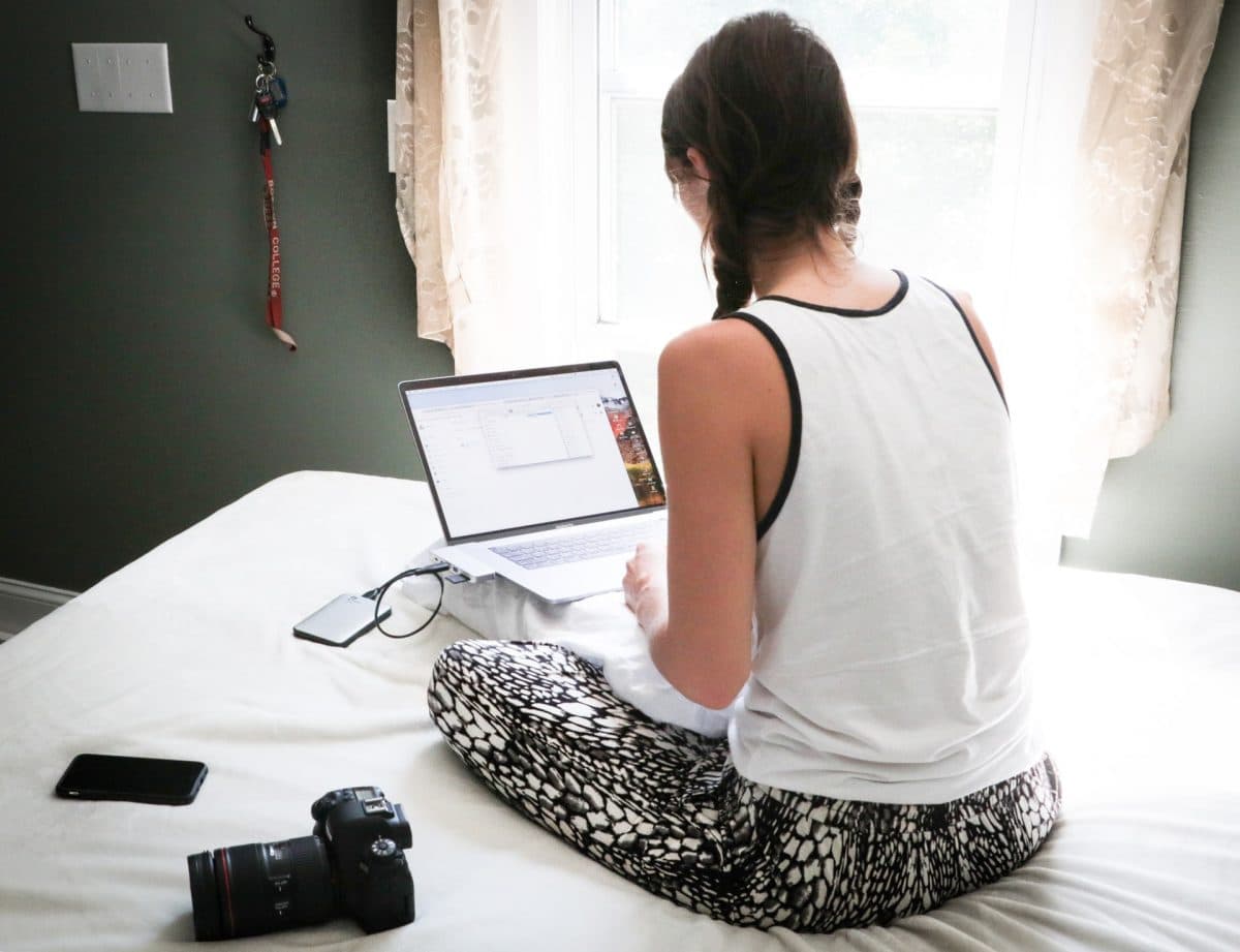 Woman using laptop on bed