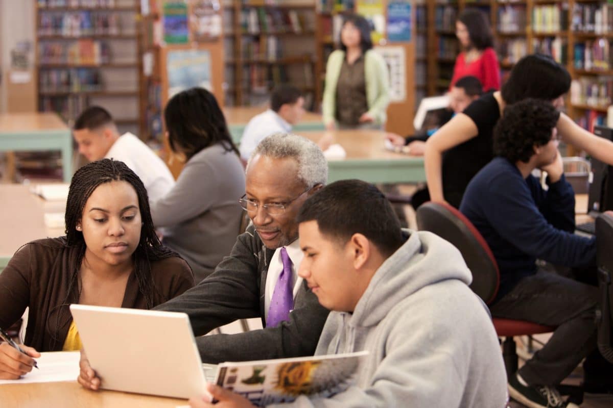 Privacy changes. Librarian helping students in school library