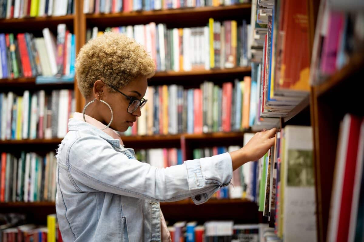 Access Lab 2025 call for proposals. Woman searching for book in library.