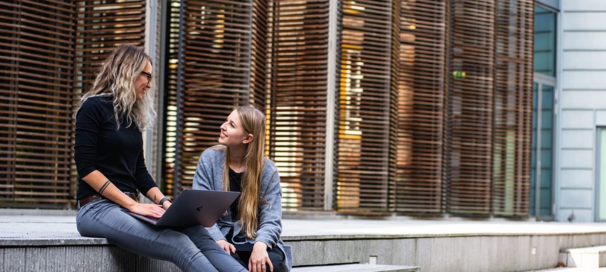 Group of people studying together around a laptop