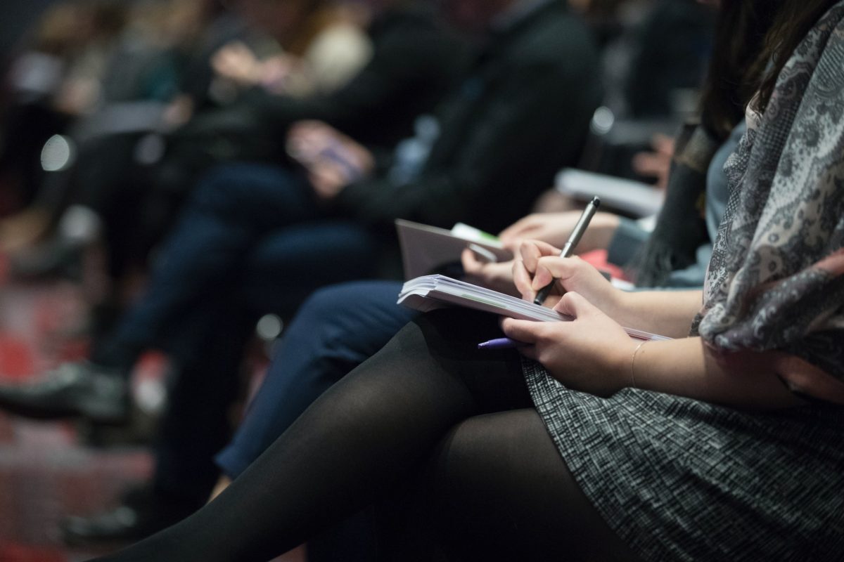 Delegates at an event choosing sponsorship options on a notepad